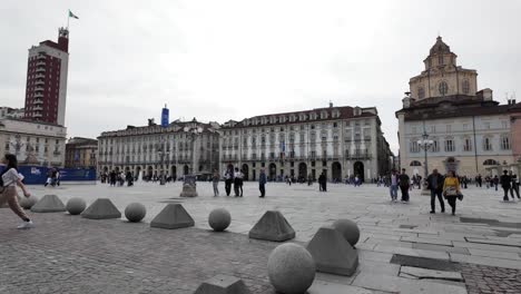 Escena-En-Cámara-Lenta-De-Personas-Caminando-Por-La-Plaza-En-Turín,-Italia,-Capturando-La-Atmósfera-Animada-Y-La-Esencia-Cultural-De-Esta-Ciudad-Histórica