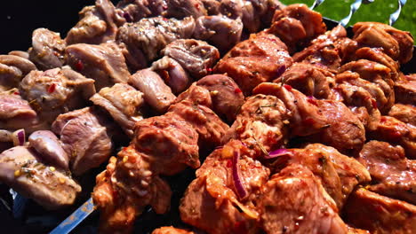 Brochetas-Parrilla-Al-Aire-Libre-En-Un-Picnic-Trozos-De-Carne-Blanca-Sazonados,-Cebolla-Chile-Rojo