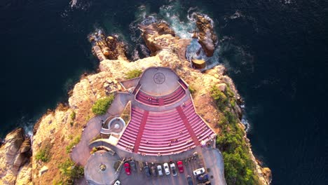 Colorful-top-down-aerial-view-of-Symphony-of-the-Sea-Amphitheater-on-a-rocky-cliff-in-Acapulco,-Mexico