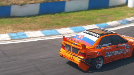 Orange-race-car-leaving-the-race-tracks-with-broken-rear-bumper