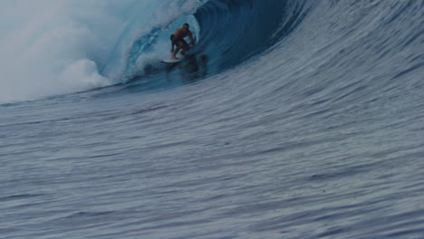 Surfer-crouches-down-as-they-get-barreled-in-heavy-wave-of-Cloudbreak-Fiji