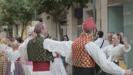 Männer-In-Traditioneller-Kleidung-Mit-Rotem-Hut,-Gemusterter-Weste-Und-Weißem-Hemd,-Die-Einen-Typischen-Ball-Von-Sagunto-In-Valencia-Tanzen-Und-Kastagnetten-Spielen