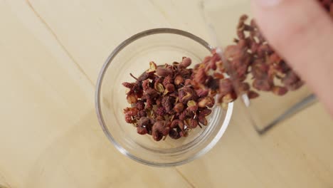 Pouring-Of-Red-Sichuan-Mala-Pepper-On-A-Clear-Glass