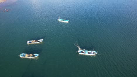 Fast-dolly-in-flight-along-Acapulco-coastline-ascends,-revealing-colorful-fishing-boats-in-turquoise-waters