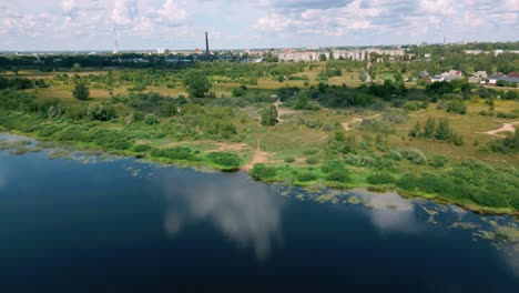 Luftaufnahmen-Von-Einem-Ruhigen-Gewässer-Zur-Skyline-Von-Daugavpils,-Der-Hauptstadt-Der-Region-Latgola-In-Lettland