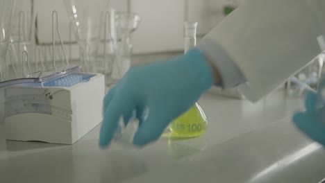 Lab-equipment-on-a-counter-with-beakers-and-a-yellow-liquid-in-a-flask