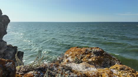 Waves-gently-crash-against-the-rocky-shoreline-as-the-sun-sets,-illuminating-the-beautiful-coastline-of-Crimea-by-the-Sea-of-Azov