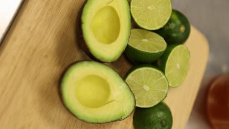 Avocados-And-Limes-Cut-In-Halves-On-A-Wooden-Chopping-Board