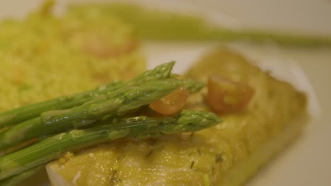 Primer-Plano-De-Un-Delicioso-Plato-Con-Espárragos,-Tomates-Cherry-Y-Pescado-Sobre-Un-Lecho-De-Arroz.