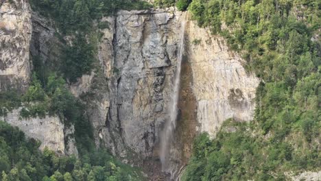 Breathtaking-view-of-Seerenbachfälle-falls-from-above-with-drone,-surrounded-by-large-rocks-and-green-trees