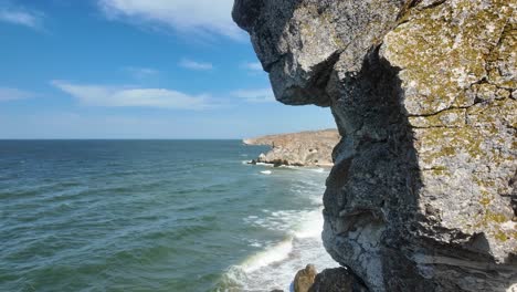 Stunning-coastal-views-of-Crimea-along-the-Sea-of-Azov,-showcasing-rocky-cliffs-and-gentle-waves-under-a-clear-blue-sky