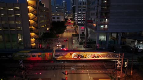 Train-passing-at-railroad-crossing-in-downtown-of-Fort-Lauderdale-at-night