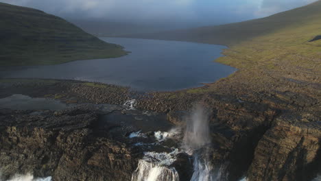 Filmischer-Sonnenuntergang-Am-See-Leitisvatn,-Färöer-Inseln:-Die-Wut-Des-Ozeans-Auf-Dem-Wasserfall