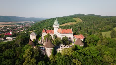 Aerial-footage-of-Smolenice-Castle-in-Slovakia,-nestled-in-lush-greenery