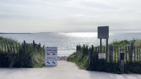 Un-Camino-Hacia-Una-Playa-En-Irlanda-Con-Algunas-Señales.