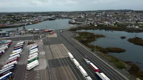 Vista-Aérea-Del-Puerto-De-Ferry-De-Holyhead,-Camiones-En-órbita-Que-Se-Cargan-En-La-Terminal-De-Stena-Line-Para-Un-Viaje-A-Irlanda