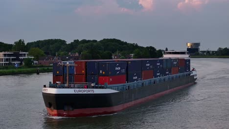 Container-ship-Euroports-sailing-on-a-river-at-dusk