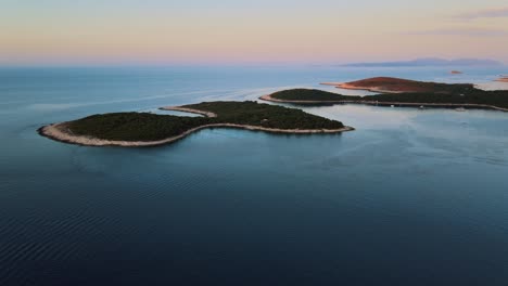 Luftaufnahme-Einer-Drohne-Von-Kleinen-Inseln-In-Der-Nähe-Der-Altstadt-Von-Hvar-Bei-Sonnenuntergang