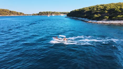 Aerial-drone-shot-of-a-small-boat-cruising-on-a-blue-seawater-near-the-coast-of-Hvar-island