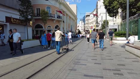 Taksim-Street-in-Istanbul,-Turkey,-bustling-with-people-walking-on-a-sunny-day,-capturing-the-vibrant-energy-and-lively-atmosphere-of-a-popular-shopping-district