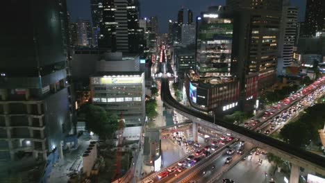 Paisaje-Urbano-Nocturno-De-Bangkok,-Tailandia,-Tráfico-Aéreo-Bullicioso-Y-Rascacielos,-Fondo-Del-Horizonte