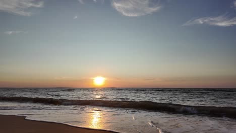 A-breathtaking-sunset-illuminates-the-horizon-over-the-Sea-of-Azov,-as-waves-gently-lap-against-the-shore-in-Crimea,-creating-a-serene-evening-atmosphere