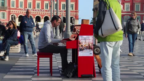 Street-performer-plays-piano-at-bustling-city-square-Place-Massena-in-Nice,-France