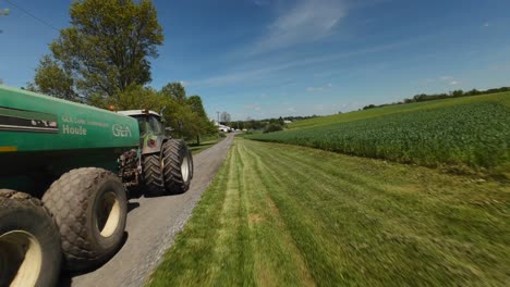 Drohnen-Kamerafahrt-Eines-Traktors-Mit-Industriellen-Güllestreuern-Für-Landwirtschaftliche-Felder-An-Sonnigen-Tagen