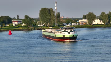 Frachtschiff-Befährt-Den-Fluss-Durch-Eine-Vorgegebene-Transportroute-Mit-Malerischer-Westeuropäischer-Landschaft