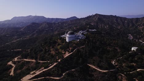 Una-Vista-Aérea-Del-Icónico-Observatorio-Griffith,-Ubicado-En-Las-Colinas-De-Los-Ángeles,-Que-Ofrece-Una-Vista-Panorámica-Del-Paisaje-Y-Los-Senderos-Circundantes.