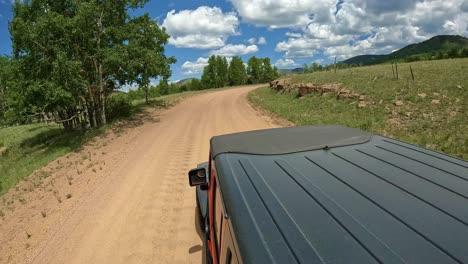 POV---View-of-vehicle-rooftop-while-driving-on-a-scenic-byway-in-Rocky-Mountains