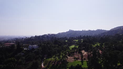 Eine-Ruhige-Luftaufnahme-Des-üppigen-Grüns-Der-Hügel-Von-Los-Angeles-Mit-Dem-Ikonischen-Griffith-Observatory,-Das-In-Der-Ferne-Sichtbar-Ist