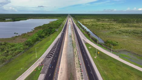 Vista-Aérea-De-Una-Intersección-Con-Tráfico-Rodeada-De-Pantanos-De-Los-Everglades-En-Florida