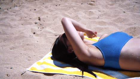 Asian-Woman-In-Swimsuit-Lying-On-Towel-On-Sand-At-Cromwell's-Beach