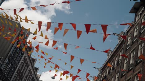 Streets-Are-Decorated-With-Orange-And-Yellow-Flags-On-King's-Day-In-Amsterdam,-Netherlands