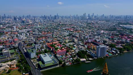 Bangkok,-Thailand,-Southeast-Asia---An-Awe-inspiring-View-of-the-Rama-VIII-Bridge-Over-the-Chao-Phraya-River,-Set-Against-the-Urban-Panorama---Aerial-Drone-Shot