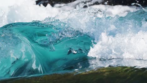 Close-up-of-powerful-flow-of-water-rushing-and-whirling-in-the-rocky-riverbed,-capturing-the-chaotic-beauty-of-nature