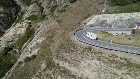 Autocaravana-Recorriendo-Una-Sinuosa-Carretera-De-Montaña-En-Los-Alpes-Suizos,-Vista-Aérea