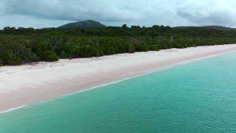 Whitehaven-Beach-white-sand-aerial-drone-Whitsundays-Island-Airlie-National-Park-Australia-AUS-QLD-rain-cloudy-blue-sky-outer-Great-Barrier-Reef-clear-blue-aqua-ocean-boat-yachts-bush-upward-motion