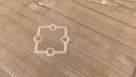 Stone-henge-square-crop-circle-formation-aerial-view-looking-down-over-golden-rural-farmland-fields