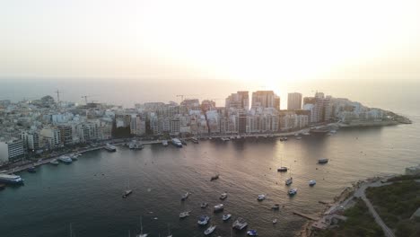 Sunrise-drone-flying-over-the-harbour-of-Sliema-and-Valletta-in-Malta