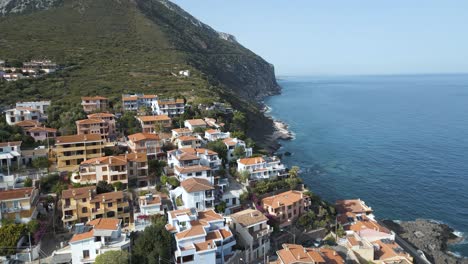 Hermosa-Ciudad-Costera-De-Cala-Gonone,-Casas-Situadas-En-Un-Acantilado-Con-Vista-Al-Océano-En-Italia