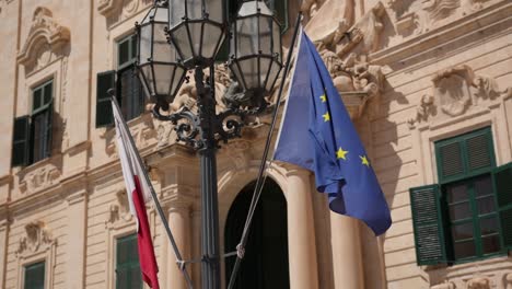 Flags-Hanging-And-Waving-In-Front-Of-The-Palace-Of-The-Prime-Minister-In-Valletta,-Malta