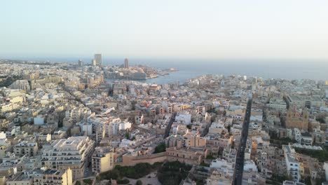 Cinematic-flight-over-Sliema,-Malta-at-sunrise