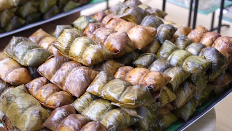 Traditionelles-Thailändisches-Dessert,-Kokos-Klebreis-Mit-Bananenblatt-Bedeckt,-Nahaufnahme