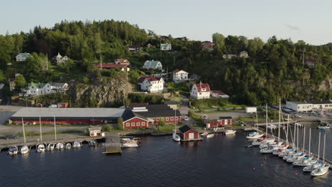 Charming-ljungskile-marina-with-boats-and-hillside-villas-in-sweden,-aerial-view