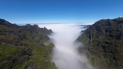 Rainbow-and-soft-white-clouds-hang-over-a-ravine