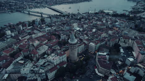 Drone-flight-around-the-galata-tower-at-the-blue-hour,-river-and-bridges-in-the-background,-Istanbul,-slow-motion,-beautiful-light