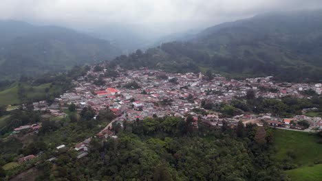 Luftaufnahmen-Umkreisen-Die-Hübsche-Stadt-Salento-Im-Nebel-Der-Anden,-Kolumbien