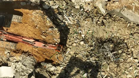 Excavator-arm-demolishing-an-old-building,-Aerial-view